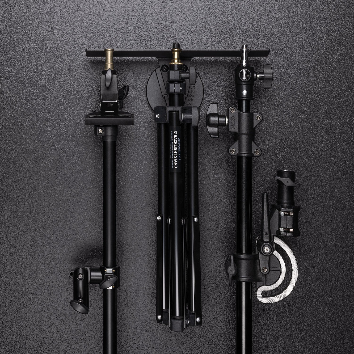 Float Wall Mount Light Stand Hanger shown with various light stands and boom components in storage