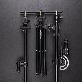 Float Wall Mount Light Stand Hanger shown with various light stands and boom components in storage