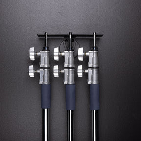 Float Wall Mount Light Stand Hanger shown with large light stands in storage